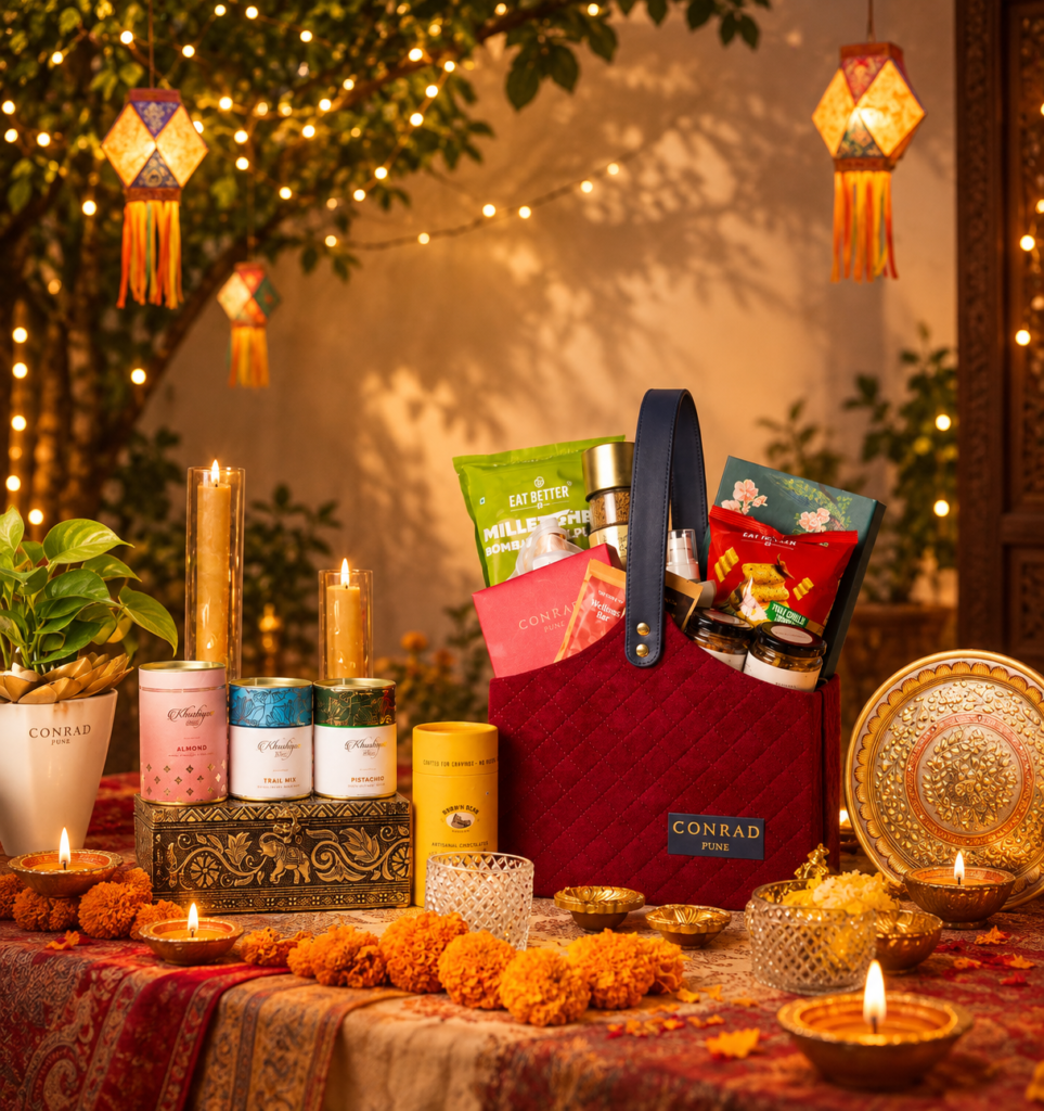 Conrad Pune Unveils Khushiyan, a Curated Collection of Luxury Diwali Gift Hampers 2026 Conrad Pune celebrates the festive season with Khushiyan, a thoughtfully curated collection of luxury Diwali gift hampers that brings together traditional Indian sweets, handcrafted chocolates, gourmet delicacies and elegant festive keepsakes. Inspired by the spirit of togetherness and the joy of giving, the collection offers a range of premium Diwali gifts designed to make festive celebrations more memorable. Featuring an assortment of gourmet treats, traditional mithai, premium nuts, speciality teas and lifestyle essentials, Khushiyan presents distinctive Diwali gift ideas for family, friends and corporate associates. With hampers ranging from INR 849 to INR 12,999, the collection caters to a variety of gifting preferences and budgets. Luxury Diwali Gift Hampers at Conrad Pune Khushiyan brings together traditional festive flavours and contemporary gourmet indulgence through a diverse selection of Diwali hampers. From handcrafted chocolates and Indian sweets to premium gourmet products and personalised gifting options, each offering reflects the spirit of festive celebration. A Glow of Sweetness - INR 849 Plus Taxes A Glow of Sweetness offers a tempting selection of handcrafted chocolate treats, including white chocolate cashew rocks, milk chocolate pistachio rocks and dark chocolate almond rocks. This thoughtfully curated assortment is an appealing option for those looking for chocolate gift hampers and affordable Diwali gifts. Luminous Moments - Starting at INR 1,349 Plus Taxes Luminous Moments celebrates traditional Indian sweets through an assortment of signature mithai. Available in 12, 16 and 25-piece selections, the offering includes Coffee Mysore Pak, Kaju Anjeer Almond Roll, Besan Ladoo, Milk Cake, Rose Date Bites and Kaju Saffron Roll. With its selection of classic Indian delicacies, this hamper is ideal for those seeking a traditional Diwali sweets gift box to share with loved ones. The Festive Fourfold - INR 1,849 Plus Taxes The Festive Fourfold presents a selection of salted almonds, salted cashews, cranberries and walnuts. Combining savoury and naturally sweet flavours, the assortment offers a versatile gifting option for festive gatherings and celebrations. Golden Blessing - INR 1,999 Plus Taxes Golden Blessing brings together Milk Cake, Rose Date Bites and Besan Ladoo, complemented by homemade salted almonds and cashews. The combination of traditional Indian sweets and premium nuts makes it a thoughtful choice for those exploring Diwali gift hampers in Pune. Diwali Éclat - INR 2,499 Plus Taxes Diwali Éclat offers a contemporary take on luxury Diwali gifts, featuring signature chocolates, cookies, coconut oil, Mexican chilli mini pretzels, crispy corn, premium nuts and handmade diyas. Blending gourmet indulgence with traditional festive accents, this hamper is designed for those who appreciate distinctive flavours and elegant presentation. Regal Indulgence - INR 3,499 Plus Taxes Regal Indulgence presents an elevated assortment of signature chocolates, cookies, peri-peri almonds, masala cashews, rose honey, iced tea, hazelnut dark chocolate and date syrup. A wooden tea-light candle adds a decorative festive touch to the selection. The hamper offers a refined combination of gourmet treats and festive keepsakes, making it a noteworthy option for premium festive gifting. Prestige Collection - INR 4,999 Plus Taxes The Prestige Collection brings together signature mithai, hazelnut dark chocolate, saffron honey, speciality tea and peanut butter. The selection also includes a vanilla-scented candle, jasmine flower soap and a hand-painted marble wall plate. Combining gourmet delicacies with lifestyle products, the hamper offers a distinctive gifting experience for those looking for premium Diwali gift hampers. Grand Legacy - INR 6,999 Plus Taxes Grand Legacy features signature mithai and chocolates, millet-based gourmet treats, premium nuts, vanilla-flavoured coffee and savoury snacks. Body lotion and sandalwood incense sticks complete the selection. With its mix of gourmet products and lifestyle essentials, the hamper offers a thoughtful way to celebrate the festive season with family, friends and professional associates. Luxe Celebration - INR 9,999 Plus Taxes Luxe Celebration presents an indulgent assortment of signature mithai, premium whole-leaf tea, blueberry walnut chocolate, dark chocolate almond butter, stuffed dates and gourmet savouries. The selection also features lavender and rosemary shampoo and a copper bottle, bringing together gourmet indulgence and lifestyle essentials in an elegant festive hamper. Royal Heritage - INR 12,999 Plus Taxes Royal Heritage represents one of the collection's most elaborate offerings. The hamper features Kashmiri saffron, A2 cow ghee, signature chocolates, premium nuts, artisanal tea, blueberry walnut chocolate and savoury delicacies. Complemented by wellness essentials and festive accents, this expansive assortment offers a distinctive choice for those seeking luxury Diwali gifts in Pune. Customised Diwali Gift Hampers at Conrad Pune For those looking for a more personalised gifting experience, Conrad Pune introduces Make Your Own Hamper, allowing guests to create bespoke assortments tailored to their preferences. Guests can select from handcrafted chocolates, cookies, macarons, premium teas and coffees, gourmet delicacies and lifestyle essentials. The customised selections can be presented in a choice of elegant packaging, including rigid boxes, velvet and leatherette baskets, and wooden hamper boxes. This flexible approach makes personalised Diwali hampers an appealing option for individual celebrations as well as corporate gifting requirements. Individual Festive Gifts and Gourmet Treats In addition to its curated hampers, Khushiyan features a selection of individual festive offerings for those who prefer smaller gifts or wish to create their own assortment. The collection includes signature cookies starting at INR 200 plus taxes, signature chocolates in a box of six priced at INR 430 plus taxes, and handcrafted macarons in a box of five priced at INR 350 plus taxes. Guests can also explore premium teas, gourmet treats and festive essentials, offering additional choices for thoughtful gifting during Diwali. Corporate Diwali Gifts and Festive Gifting in Pune Diwali is an occasion to celebrate relationships, express appreciation and share meaningful gifts. With its varied hamper sizes, premium products and customisation options, Khushiyan by Conrad Pune offers a range of possibilities for corporate Diwali gifts. Businesses can explore curated assortments for clients, colleagues and associates, while individuals can choose from traditional Indian sweets, handcrafted chocolates and gourmet selections for friends and family. The collection brings together festive tradition and contemporary presentation, making it a relevant option for those searching for corporate Diwali gifts and luxury festive hampers in Pune. Celebrate Diwali with Khushiyan by Conrad Pune With its combination of traditional Indian mithai, handcrafted chocolates, premium gourmet treats and elegant keepsakes, Khushiyan celebrates the spirit of Diwali through thoughtful gifting. From A Glow of Sweetness and Luminous Moments to the Royal Heritage hamper, the collection offers a diverse range of options for different preferences and occasions. The Make Your Own Hamper experience adds further flexibility for those seeking personalised festive gifts. For those exploring Diwali gift ideas for 2026, luxury Diwali gift hampers or premium festive gifting in Pune, Khushiyan by Conrad Pune presents a curated collection that brings together flavour, tradition and the joy of giving. Prices mentioned are exclusive of applicable taxes, as specified. Individual offerings, hamper contents and customisation options are based on the collection details provided.